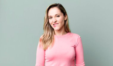 Şaşırmış ve kafası karışmış görünüyor, sinirsel bir hareketle dudağını ısırıyor, sorunun cevabını bilmiyor.