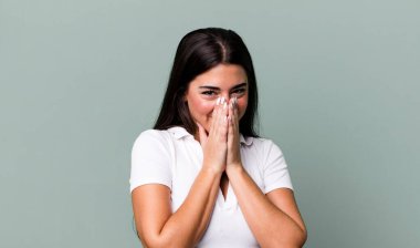 Mutlu, neşeli, şanslı ve şaşkın görünüyor iki eliyle ağzını kapatıyor.