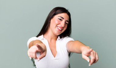 Mutlu ve kendinden emin hissetmek, kameraya iki elinle işaret etmek ve gülmek, seni seçmek.