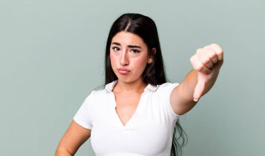 Kızgın, sinirli, hayal kırıklığına uğramış ya da hoşnutsuz, ciddi bir bakışla başparmaklarını aşağı gösteren.