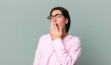 Sabahın köründe tembelce esniyor, uykulu, yorgun ve sıkkın görünüyor.