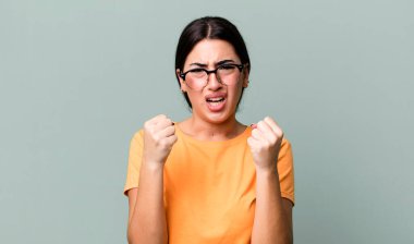 Sinirli, hayal kırıklığına uğramış, kızgın bakışlar ve sıkı yumruklarla bağırmak, öfkeli hissetmek.