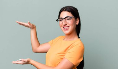 gülümseyen, mutlu, pozitif ve tatmin olmuş hisseden, kopya uzayı üzerinde nesne veya konsept tutan veya gösteren