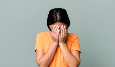 Üzgün, hayal kırıklığına uğramış, gergin ve depresif, iki eliyle yüzünü kaplayan, ağlayan