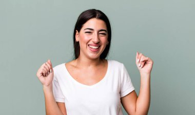 Son derece mutlu ve şaşırmış görünüyor, başarıyı kutluyor, bağırıyor ve zıplıyor.