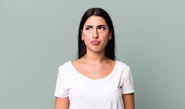 Şaşırmış ve kafası karışmış görünüyor, merak ediyor ya da bir sorunu çözmeye çalışıyor.