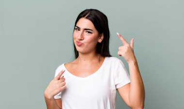 Kibirli ve agresif görünen, yukarıyı gösteren ya da ellerinle alay eden bir tavır takınarak.