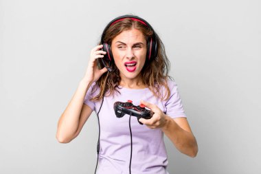 hispanic pretty young woman playing with headphones and a control. gamer concept