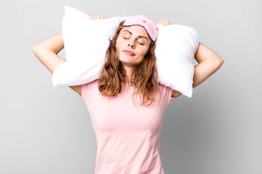 hispanic pretty young woman wearing pajamas night wear and a pillow