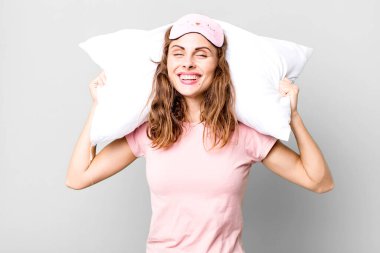 hispanic pretty young woman wearing pajamas night wear and a pillow