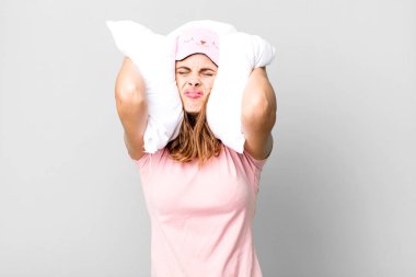 hispanic pretty young woman wearing pajamas night wear and a pillow