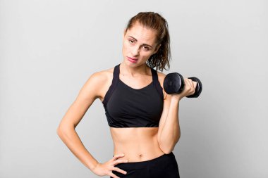 hispanic pretty young woman lifting a dumbbell. fitness concept