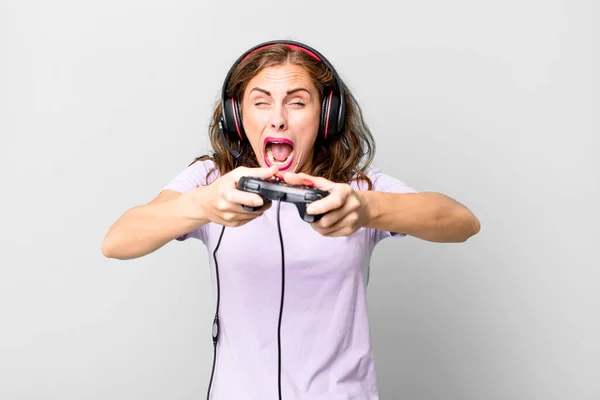 ヒスパニックはヘッドフォンとコントロールで遊んでる若い女性だ ゲーマーのコンセプト — ストック写真