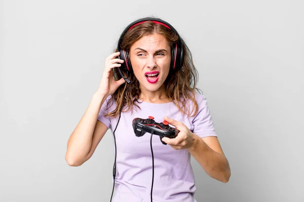 ヒスパニックはヘッドフォンとコントロールで遊んでる若い女性だ ゲーマーのコンセプト — ストック写真