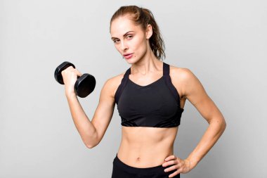 hispanic pretty young woman lifting a dumbbell. fitness concept