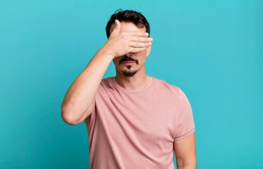 Bir eliyle gözlerini kapatıyor korkmuş ya da endişeli, merak ediyor ya da körü körüne bir sürpriz bekliyor.