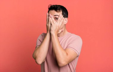 Yüzü ellerle kaplamak, parmaklarının arasından bakmak şaşırmış bir ifadeyle yan tarafa bakmak.