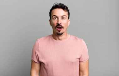 Şok olmuş ya da şaşırmış görünüyor, ağzı açık bakıyor ve 