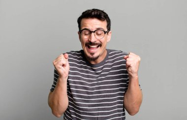 Son derece mutlu ve şaşırmış görünüyor, başarıyı kutluyor, bağırıyor ve zıplıyor.