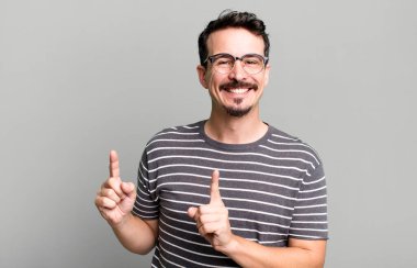 Gülümseyen ve her iki elinle yukarı ve yana doğru gösteren nesne kopyalama boşluğunda