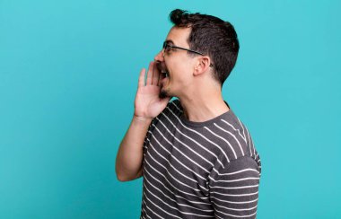 Profil görünümü, mutlu ve heyecanlı görünüyor, bağırıyor ve kenardaki boşluğu kopyalamak için arıyor