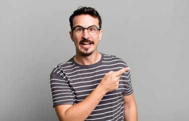 Heyecanlı ve şaşırmış görünüyor. Yana ve yukarıya bakıyor. Boşluğu kopyalıyor.