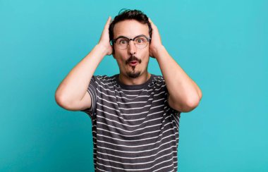 Heyecanlı ve şaşırmış görünüyor, ağzı açık, elleri başının üstünde, şanslı bir kazanan gibi hissediyor.