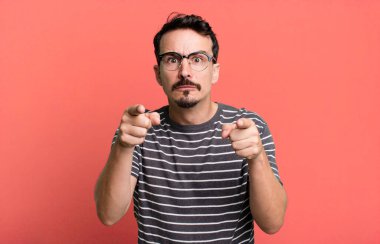 Kamerayı iki parmağınla ve kızgın bir ifadeyle sana görevini yapmanı söylüyor.