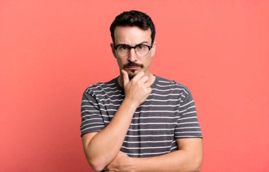 Ciddi görünüyor, kafası karışık, kararsız ve düşünceli, seçenekler ve seçimler arasında şüpheci