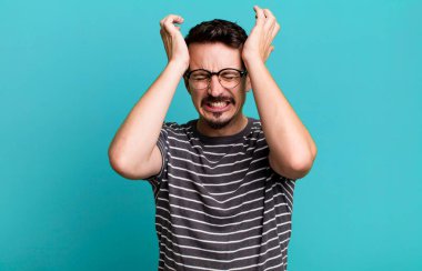 Stresli ve endişeli hissediyorum, depresif ve hayal kırıklığına uğramış, iki elini de başa kaldırıyor.