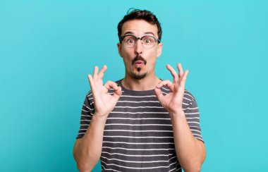 Şaşırmış, şaşırmış ve şaşırmış hissediyorsun. Onayladığını gösteriyorsun. İki elinle de onay imzası atıyorsun.