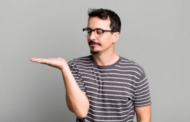 Mutlu olmak ve gelişigüzel gülümsemek, elde tutulan bir nesneye ya da konsepte bakmak