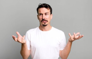 Aptal, çılgın, şaşkın, şaşkın bir ifadeyle omuz silkmek, rahatsız ve cahil hissetmek.