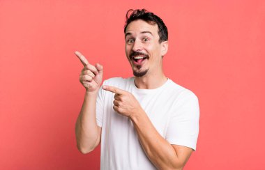 Neşeli ve şaşırmış hissediyorum, şok olmuş bir ifadeyle gülümsüyorum ve bir tarafı işaret ediyorum.