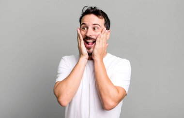 Mutlu, heyecanlı ve şaşırmış hissediyorum, iki elimle de yana bakıyorum.