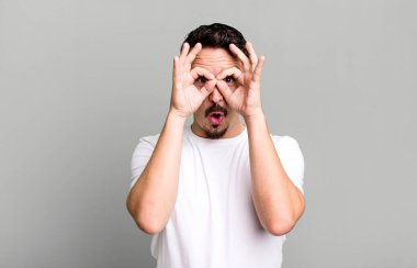 Şaşırmış, şaşırmış ve şaşırmış hissediyorum, şaşkın ve inanmayan bir bakışla gözlük tutuyor.