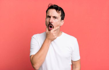 Ağzı ve gözleri açık ve elleri çenesinde, nahoş bir şekilde şokta, ne diyor ya da vay be