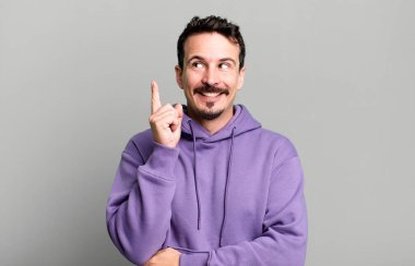 Mutlu bir şekilde gülümsemek ve yan bakmak, merak etmek, düşünmek ya da bir fikir sahibi olmak.