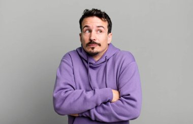 Omuz silkmek, kafası karışık ve kararsız hissetmek, kolları çapraz ve şaşkın bir bakış ile şüpheye düşmek