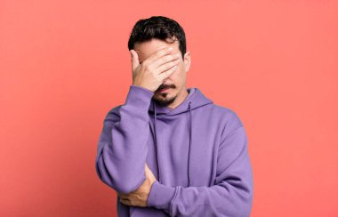 Stresli, utanmış ya da üzgün görünüyordu. Baş ağrısı vardı. Yüzü elle kaplıydı.