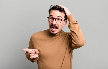 Gülüyor, mutlu, pozitif ve şaşırmış görünüyor. Yan fotokopi alanını işaret eden harika bir fikri fark ediyor.