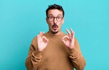 Şaşırmış, şaşırmış ve şaşırmış hissediyorsun. Onayladığını gösteriyorsun. İki elinle de onay imzası atıyorsun.