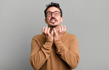 Çaresiz ve hayal kırıklığına uğramış görünüyor, stresli, mutsuz ve sinirli, bağırıyor ve çığlık atıyor