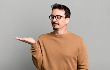 Mutlu olmak ve gelişigüzel gülümsemek, elde tutulan bir nesneye ya da konsepte bakmak