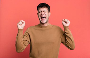 Adam son derece mutlu ve şaşırmış görünüyor, başarıyı kutluyor, bağırıyor ve zıplıyor