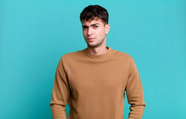 Adam gururlu, kendinden emin, havalı, küstah ve küstah görünüyor, gülümsüyor, başarılı hissediyor.