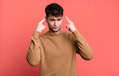 Kötü tavırlı bir adam gururlu ve agresif görünüyor, yukarıyı gösteriyor ya da elleriyle alay işareti yapıyor.