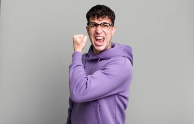 Kendini mutlu, tatmin olmuş ve güçlü hisseden, kasları kaslı, kaslı, spor salonundan sonra güçlü görünen bir adam.