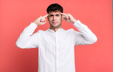 Ciddi ve konsantre görünümlü bir adam, beyin fırtınası yapıyor ve zorlu bir sorunu düşünüyor.