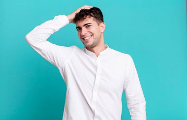 Neşeli ve tesadüfen gülümseyen bir adam, olumlu, mutlu ve kendinden emin bir bakışla göğüs göğüse tutuşuyor.